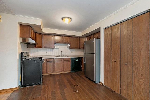 kitchen featuring under cabinet range hood, a sink, light countertops, dark wood-style floors, and black appliances