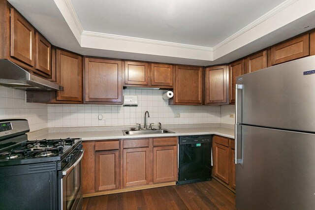 kitchen featuring stainless steel appliances, light countertops, brown cabinetry, a sink, and under cabinet range hood