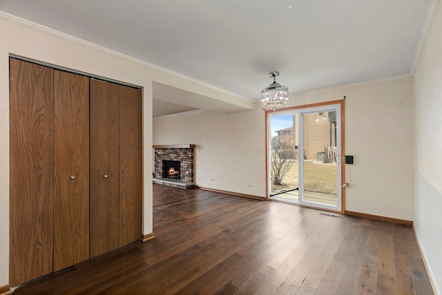 unfurnished dining area featuring baseboards, visible vents, ornamental molding, dark wood-type flooring, and a fireplace