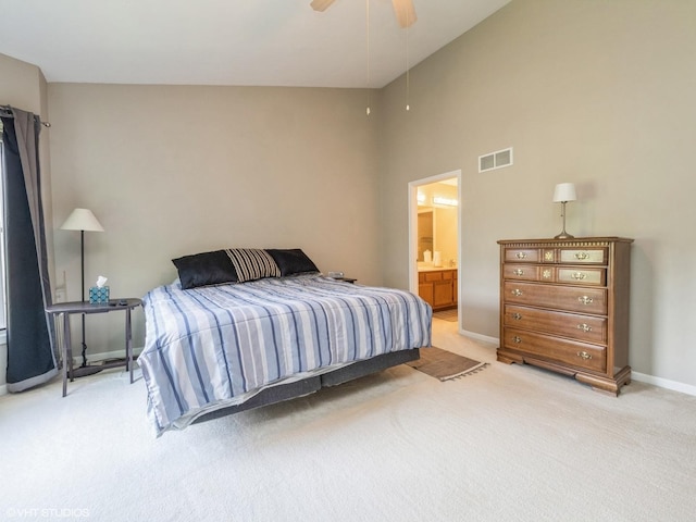 bedroom with light carpet, baseboards, visible vents, ensuite bath, and ceiling fan