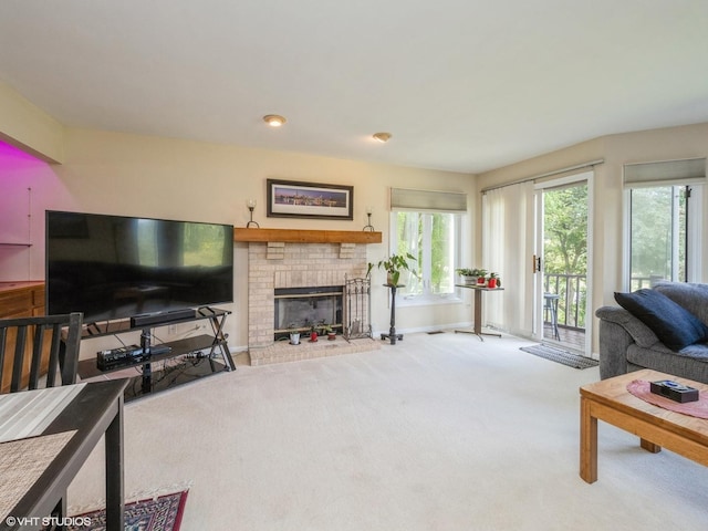 living area featuring a fireplace, baseboards, and carpet flooring