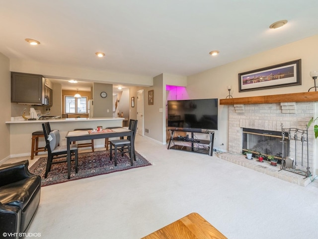 living area featuring recessed lighting, a fireplace, baseboards, and light colored carpet