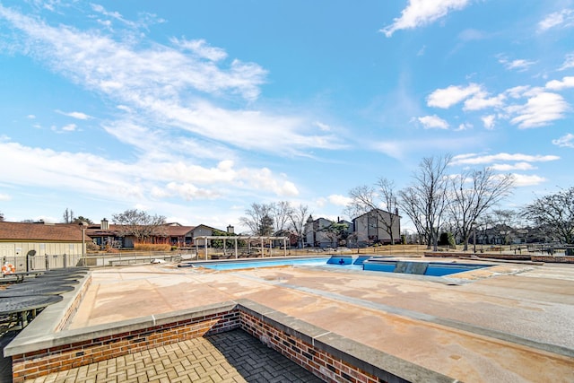 pool featuring a patio area, fence, and a residential view