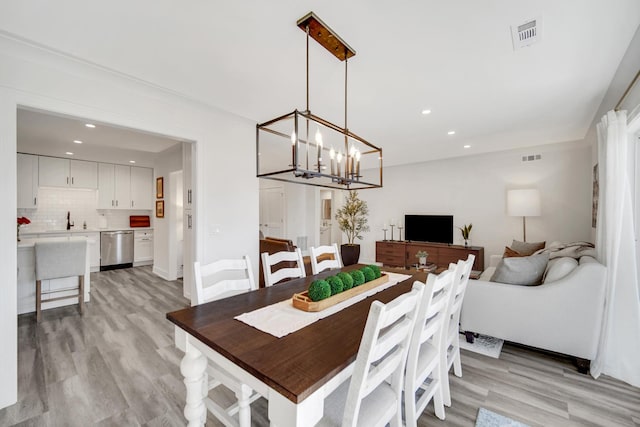 dining room with light wood-style flooring, visible vents, a chandelier, and recessed lighting