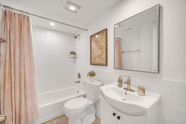 bathroom with shower / bath combo, visible vents, toilet, vanity, and tile walls