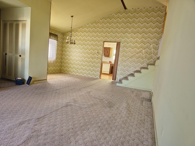 unfurnished living room featuring carpet flooring, vaulted ceiling, and stairs