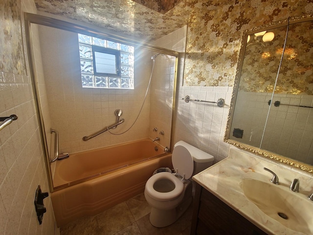 full bathroom featuring wallpapered walls, toilet, tile patterned floors, vanity, and tile walls