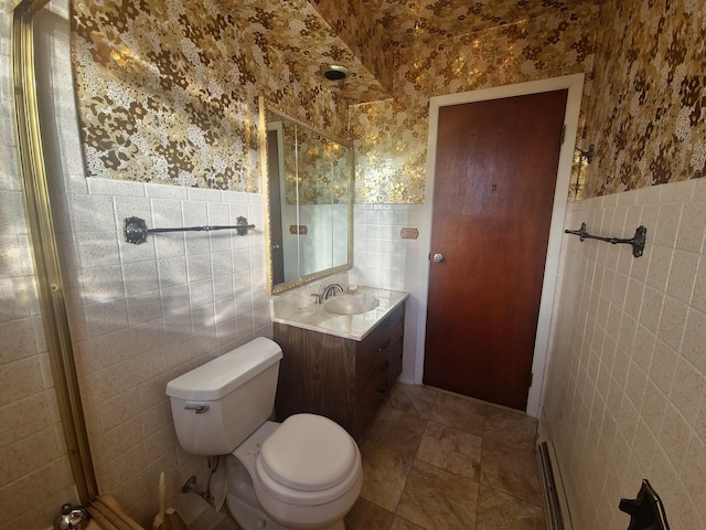 bathroom with toilet, tile walls, vanity, and wallpapered walls