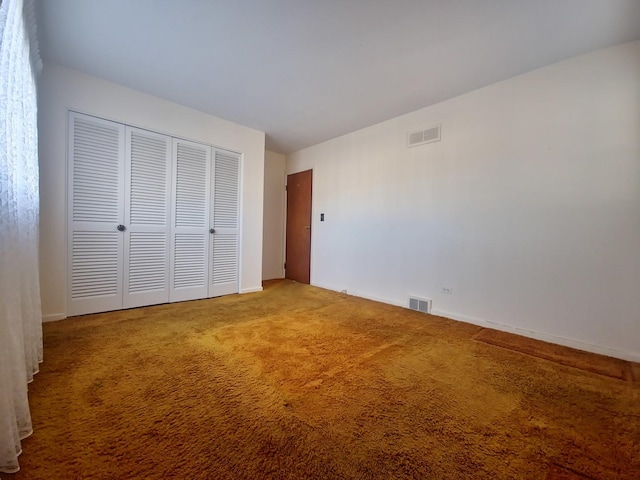 unfurnished bedroom featuring carpet floors, a closet, and visible vents