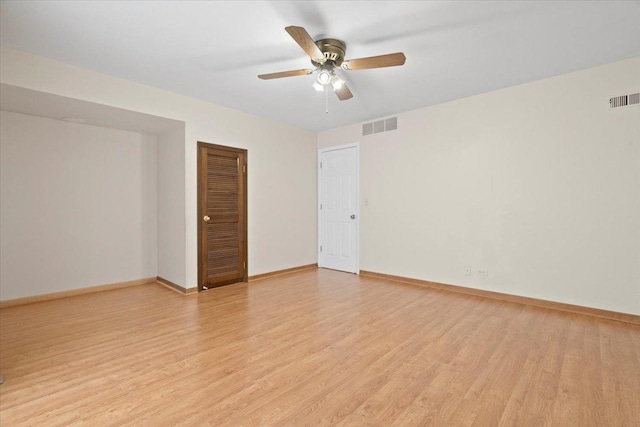 unfurnished room featuring light wood-type flooring, baseboards, and visible vents