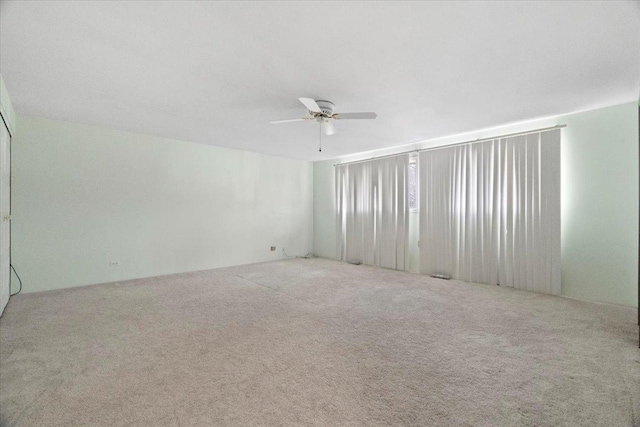 carpeted spare room featuring ceiling fan