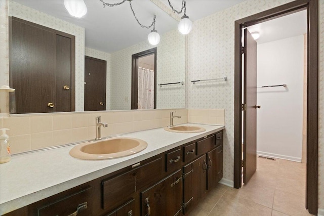 bathroom with double vanity, a sink, visible vents, and wallpapered walls