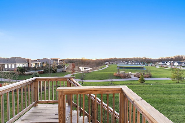 wooden terrace featuring a residential view and a yard