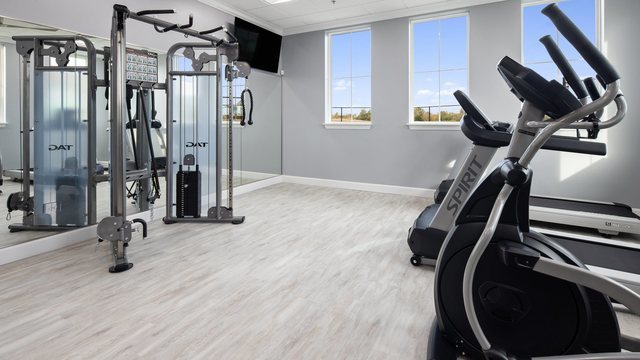 exercise room with baseboards and wood finished floors