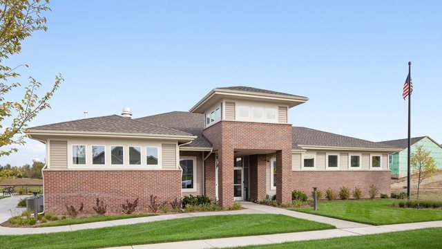 prairie-style house with a front lawn and brick siding