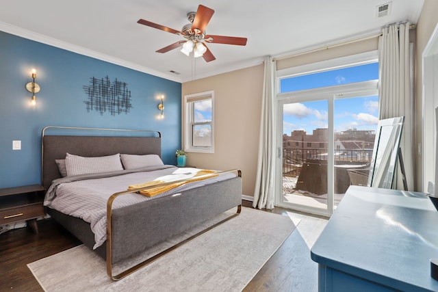 bedroom featuring access to exterior, multiple windows, visible vents, and wood finished floors