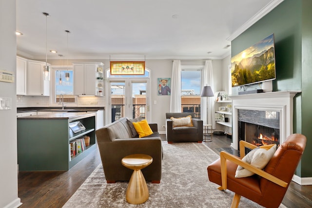 living room featuring baseboards, dark wood-style flooring, crown molding, a fireplace, and recessed lighting