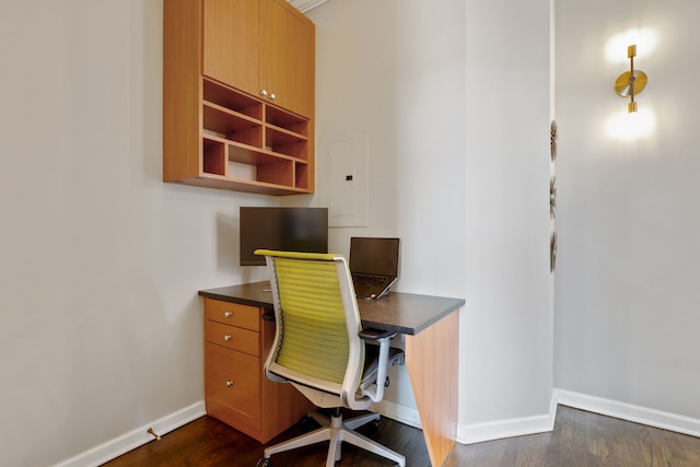 office with dark wood-type flooring, electric panel, and baseboards