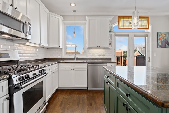 kitchen featuring stainless steel appliances, white cabinets, green cabinetry, and crown molding