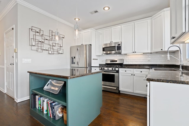 kitchen featuring decorative backsplash, ornamental molding, stainless steel appliances, and a sink