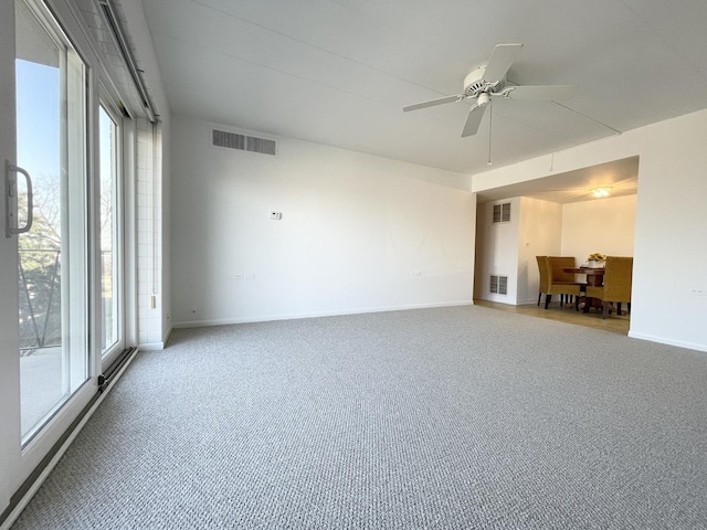 carpeted spare room with visible vents, ceiling fan, and baseboards