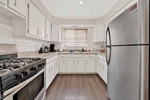 kitchen with decorative backsplash, white cabinets, dark wood-style floors, appliances with stainless steel finishes, and a sink