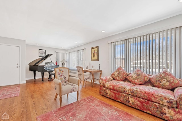 living area featuring recessed lighting, baseboards, and light wood finished floors