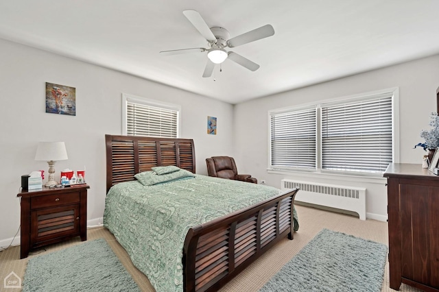 bedroom featuring radiator heating unit, multiple windows, and baseboards