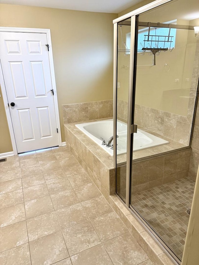 bathroom with a bath, a shower stall, and tile patterned floors