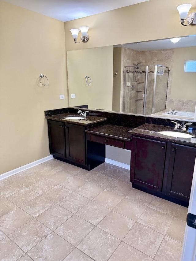 bathroom with vanity, a shower stall, a bath, and baseboards