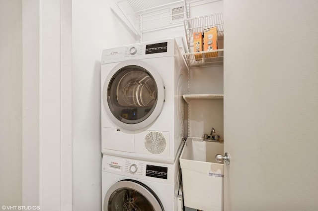 laundry room featuring stacked washer and dryer, laundry area, and a sink