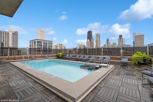 view of swimming pool with a view of city, fence, and a patio