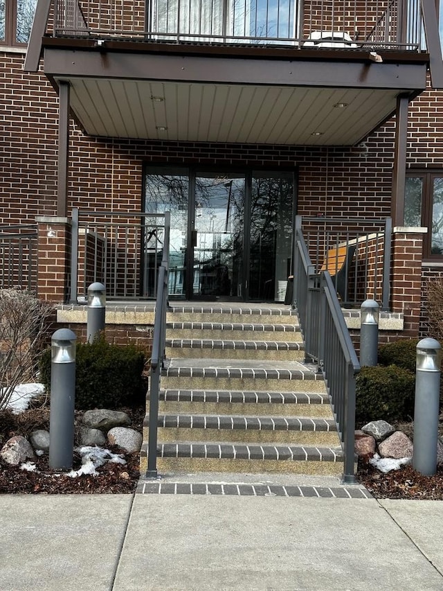 view of exterior entry featuring brick siding