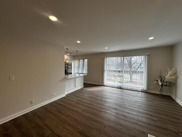 unfurnished living room with baseboards, dark wood-type flooring, and recessed lighting