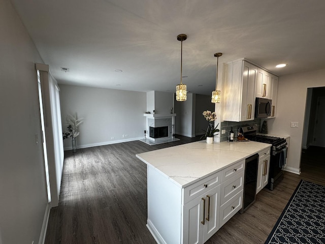 kitchen featuring light stone counters, baseboards, range with gas stovetop, and dark wood-style flooring