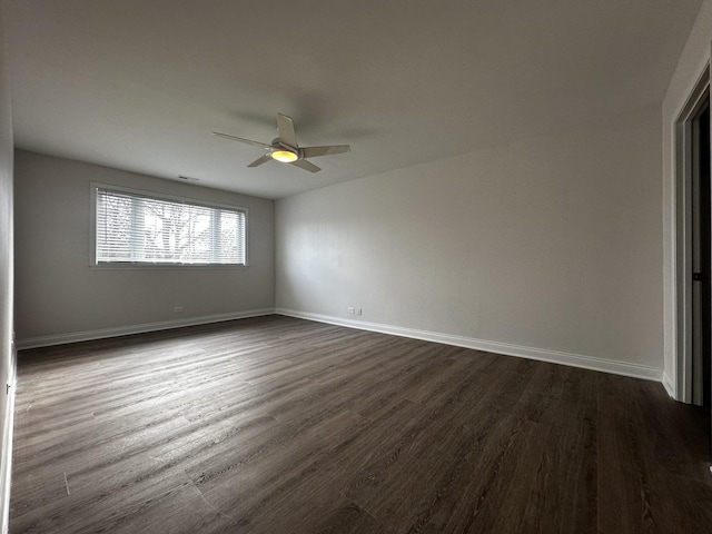 spare room featuring dark wood-type flooring, baseboards, and a ceiling fan