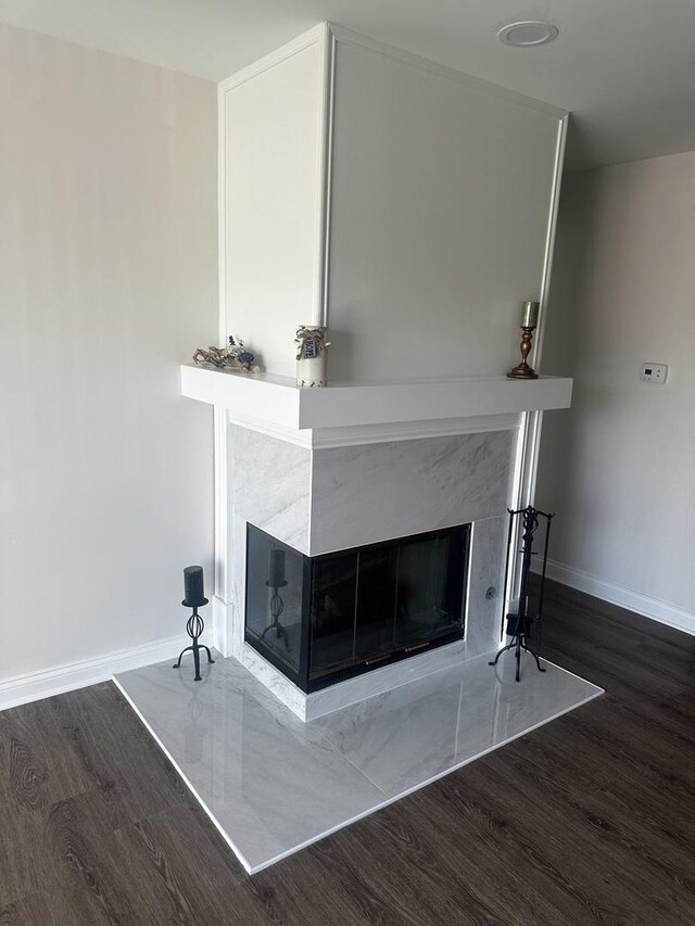 details with a fireplace, wood finished floors, and baseboards