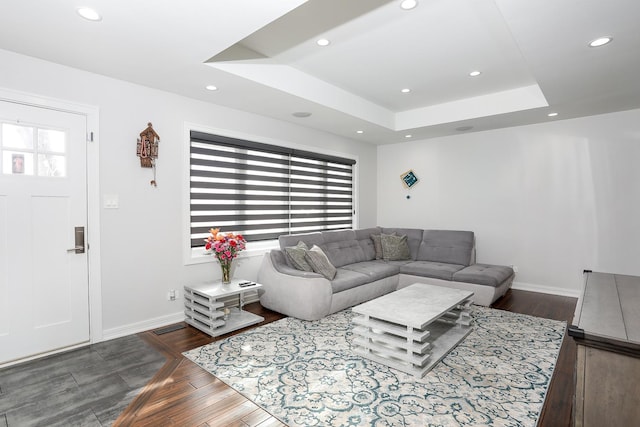 living area featuring dark wood-style floors, plenty of natural light, a tray ceiling, and recessed lighting