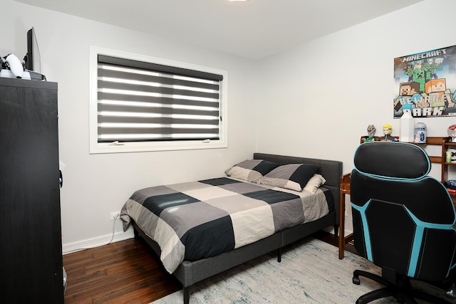 bedroom featuring wood finished floors and baseboards