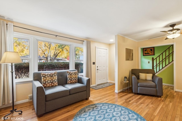 living area with light wood-style floors, visible vents, stairs, and baseboards