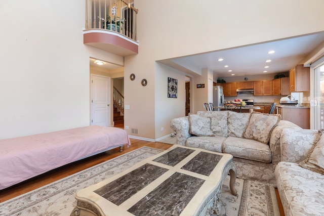 living room with stairs, baseboards, wood finished floors, and recessed lighting