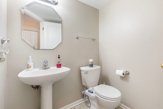 bathroom with tile patterned flooring, toilet, and baseboards