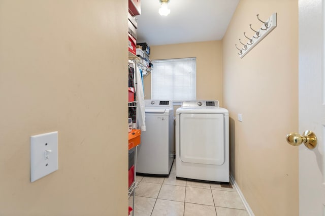 washroom with light tile patterned floors, laundry area, and washing machine and dryer