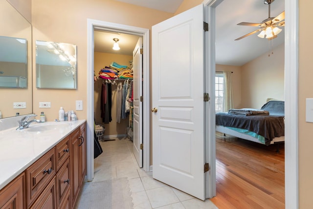 bathroom featuring a ceiling fan, tile patterned flooring, a spacious closet, and vanity