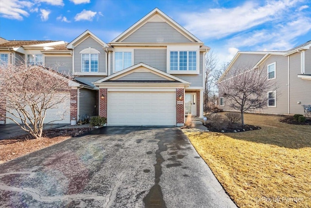 view of front of property with a garage, aphalt driveway, a front lawn, and brick siding