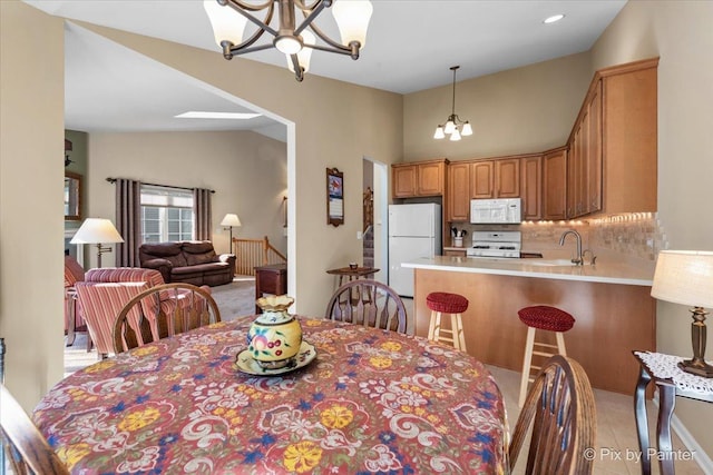 dining space featuring lofted ceiling, light tile patterned floors, and a notable chandelier