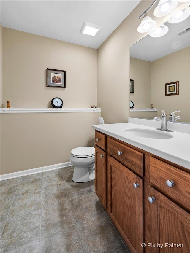 bathroom with toilet, baseboards, visible vents, and vanity