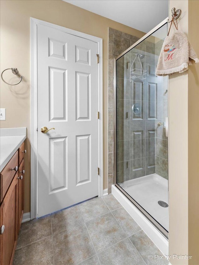 full bathroom featuring a stall shower, vanity, and tile patterned floors