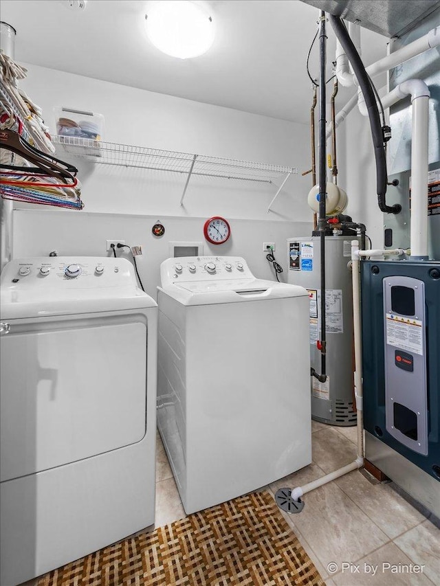 washroom with laundry area, washing machine and dryer, and water heater