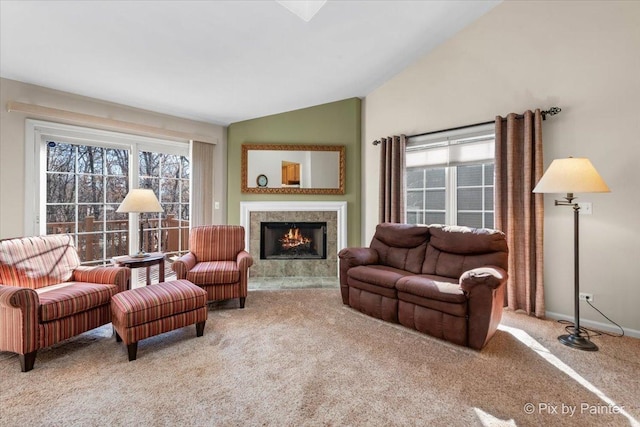 living area featuring a healthy amount of sunlight, carpet, vaulted ceiling, and a tiled fireplace